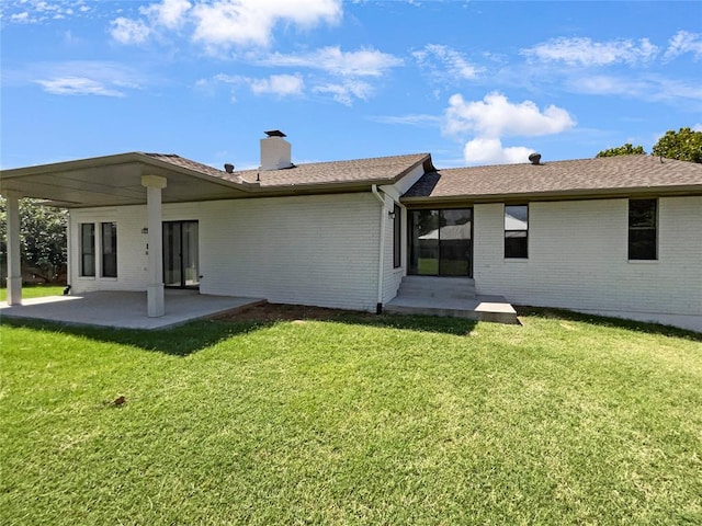 rear view of property featuring a patio area and a lawn