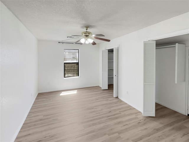 unfurnished bedroom with a textured ceiling, light hardwood / wood-style floors, and ceiling fan