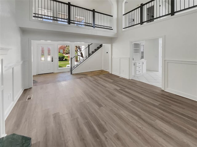 entryway with a towering ceiling and light hardwood / wood-style floors