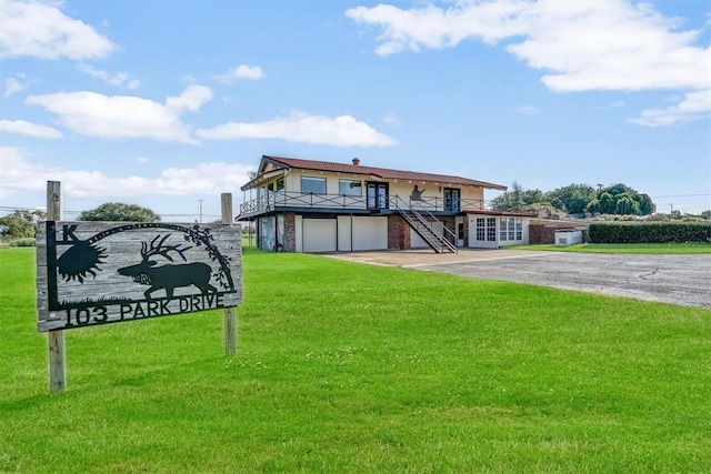 103 Park Dr, Sayre, OK 73662 - view of front of home with stairs, a front lawn, an attached garage, driveway, and brick siding