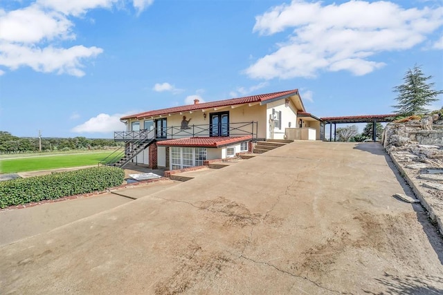 103 Park Dr, Sayre, OK 73662 - view of front of property featuring stairs, concrete driveway, stucco siding, a carport, and a chimney