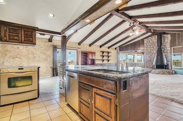 kitchen with stainless steel dishwasher, lofted ceiling with beams, white electric stove, a wood stove, and an island with sink