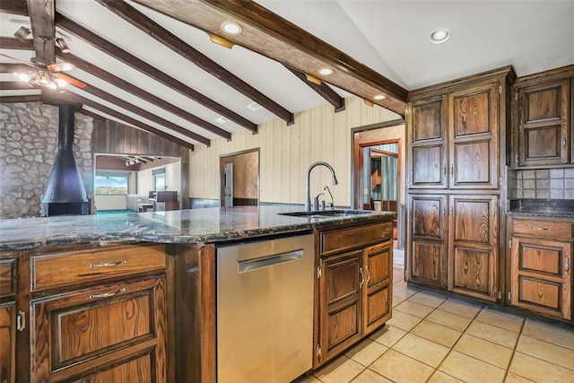 kitchen featuring stainless steel dishwasher, lofted ceiling with beams, a wood stove, and sink