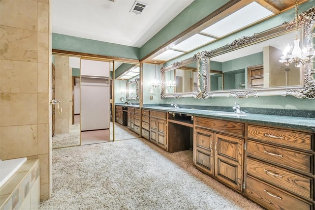 103 Park Dr, Sayre, OK 73662 - full bathroom featuring double vanity, a tub to relax in, and a chandelier