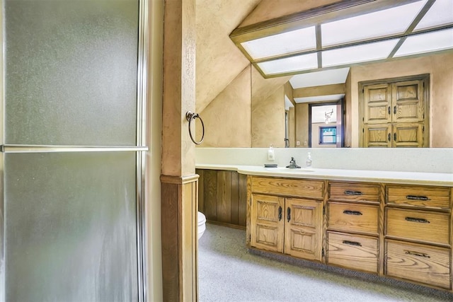 bathroom with toilet, vanity, vaulted ceiling, and walk in shower