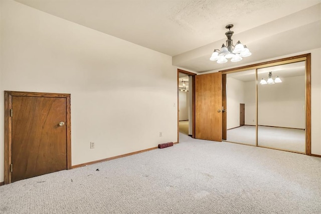 carpeted spare room with a notable chandelier