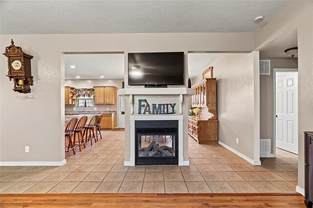 living room featuring a multi sided fireplace and light hardwood / wood-style flooring