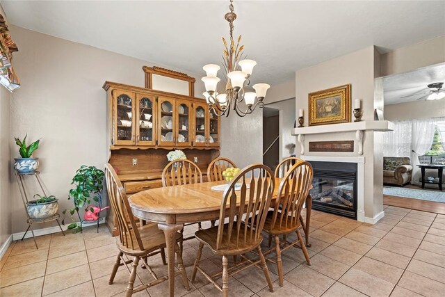 dining area with ceiling fan with notable chandelier and light tile patterned floors