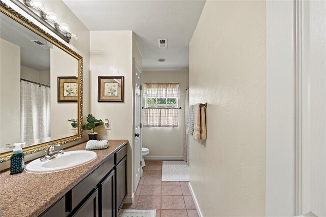 bathroom featuring tile patterned floors, vanity, and toilet