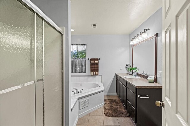 bathroom featuring plus walk in shower, vanity, and tile patterned floors