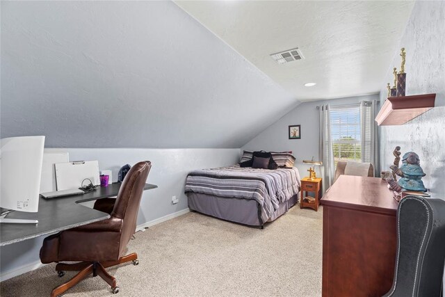 bedroom with a textured ceiling, light carpet, and vaulted ceiling