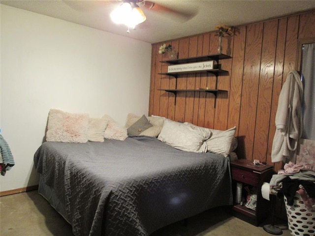 carpeted bedroom with ceiling fan and wood walls