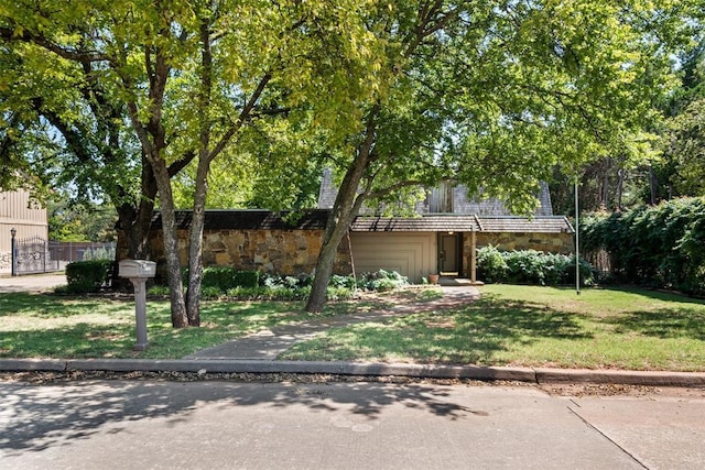 obstructed view of property with a front lawn