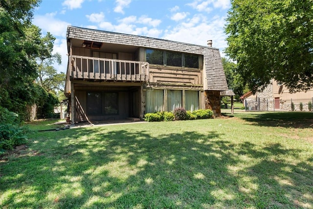 rear view of house featuring a yard