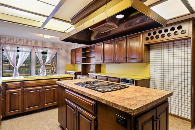 kitchen featuring a kitchen island, dark brown cabinets, sink, and black cooktop