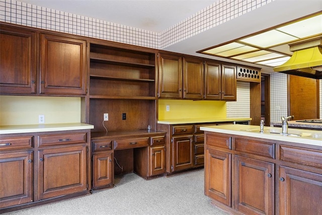 kitchen with light carpet, sink, built in desk, and black electric cooktop