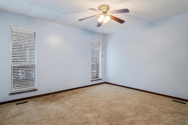 spare room featuring ceiling fan, carpet, and a textured ceiling