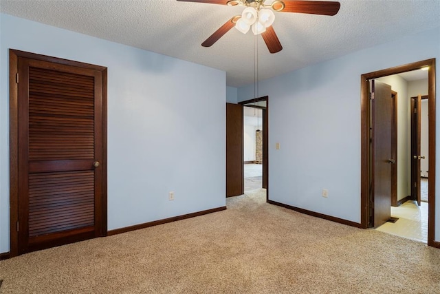 unfurnished bedroom with light carpet, ceiling fan, and a textured ceiling