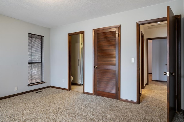 unfurnished bedroom featuring light carpet and a textured ceiling