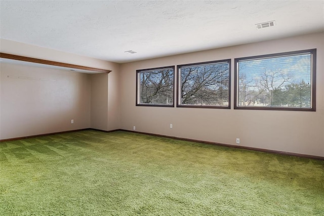 empty room with carpet and a textured ceiling