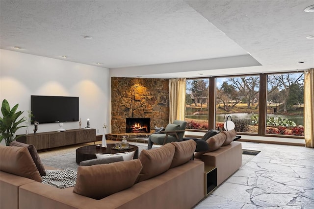 living room with a stone fireplace and a textured ceiling