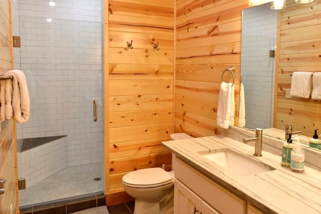 bathroom featuring wooden walls, a shower with door, vanity, and toilet