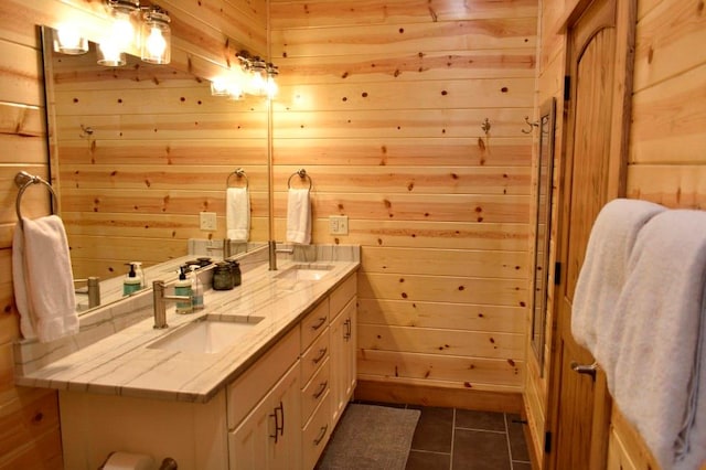 bathroom with tile patterned flooring, vanity, and wooden walls