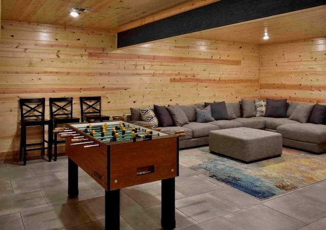 rec room with tile patterned floors, wood walls, and wood ceiling