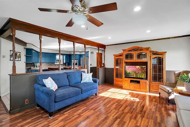 living room with hardwood / wood-style flooring, ceiling fan, and crown molding