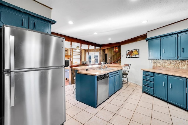 kitchen with blue cabinetry, sink, tasteful backsplash, crown molding, and appliances with stainless steel finishes