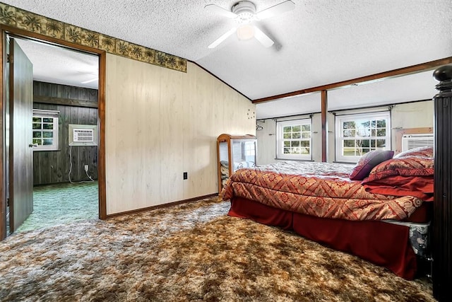 carpeted bedroom with a textured ceiling, ceiling fan, an AC wall unit, lofted ceiling, and wood walls