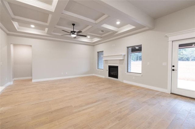 unfurnished living room featuring beamed ceiling, light wood-type flooring, a glass covered fireplace, and baseboards