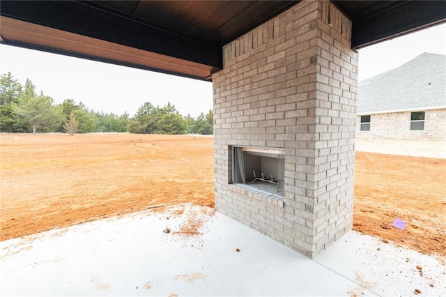 view of patio with an outdoor brick fireplace