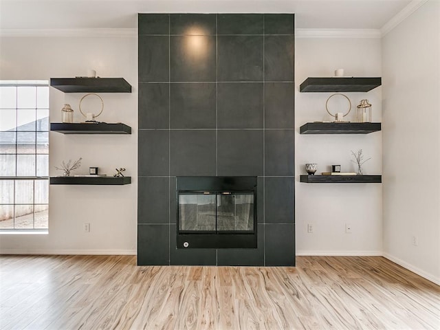 room details with hardwood / wood-style floors, ornamental molding, and a tile fireplace