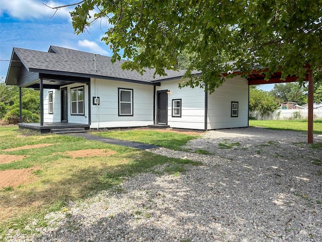 view of front of property featuring a carport, a porch, and a front lawn