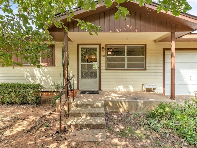 property entrance with covered porch and a garage