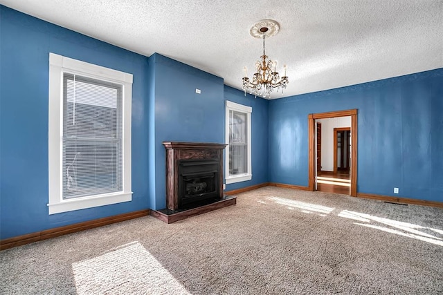 unfurnished living room featuring carpet, a textured ceiling, and an inviting chandelier