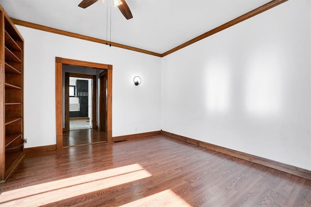 empty room with crown molding, dark hardwood / wood-style flooring, and ceiling fan