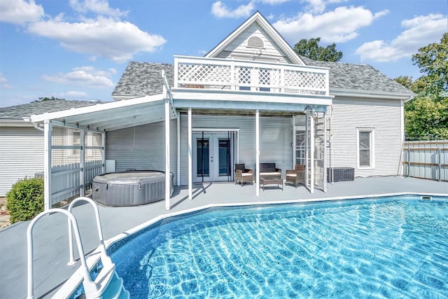 view of swimming pool with a patio area, french doors, and a hot tub