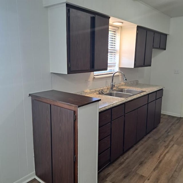 kitchen featuring dark brown cabinets, dark hardwood / wood-style flooring, and sink