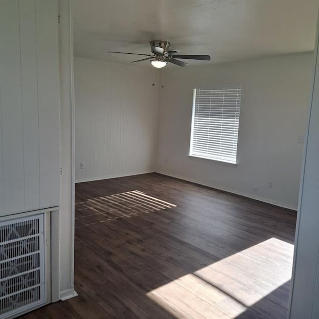 empty room with ceiling fan and dark hardwood / wood-style flooring