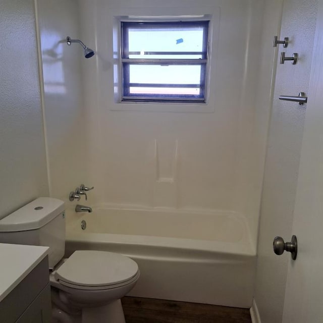 full bathroom with hardwood / wood-style flooring, vanity, shower / bath combination, and toilet