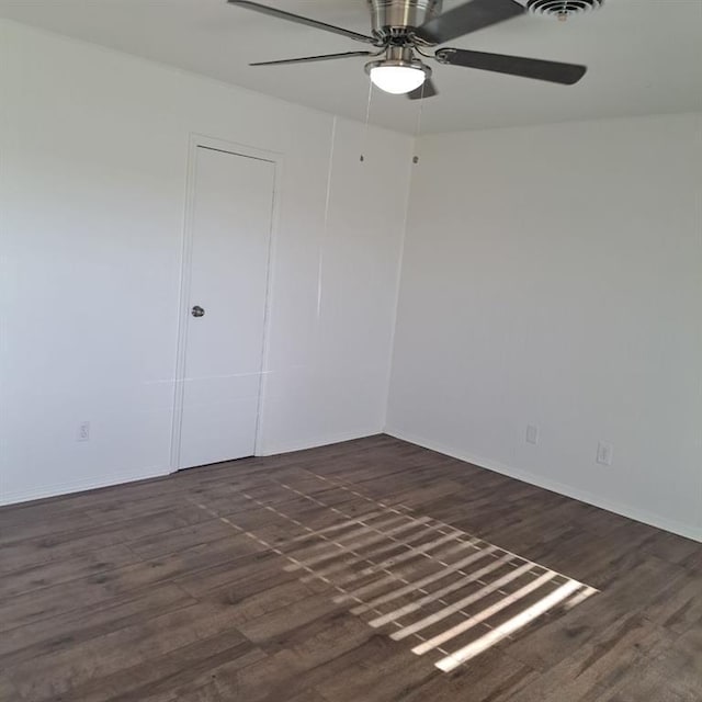 spare room featuring dark hardwood / wood-style flooring and ceiling fan