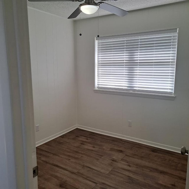 unfurnished room with ceiling fan, dark hardwood / wood-style flooring, and a textured ceiling