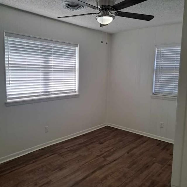 spare room featuring ceiling fan and dark wood-type flooring