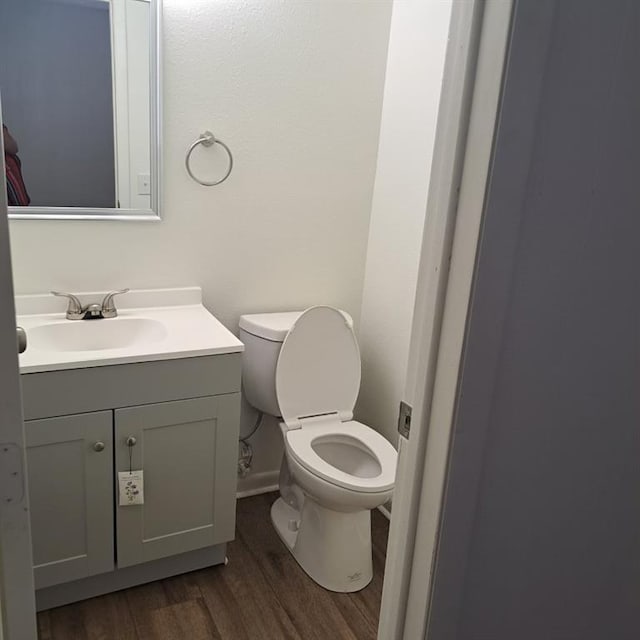 bathroom with hardwood / wood-style floors, vanity, and toilet