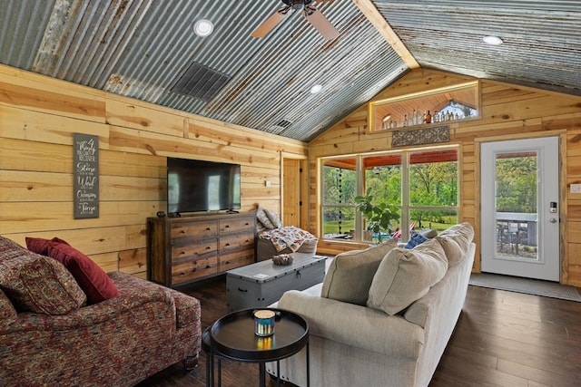 living room with dark hardwood / wood-style floors, ceiling fan, lofted ceiling, and wooden walls