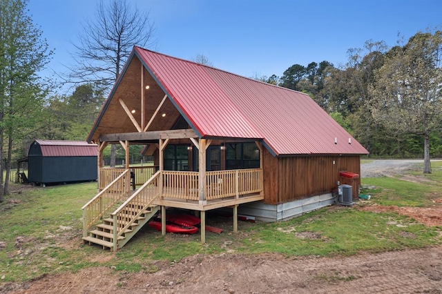 rear view of property with central air condition unit, a shed, and a deck