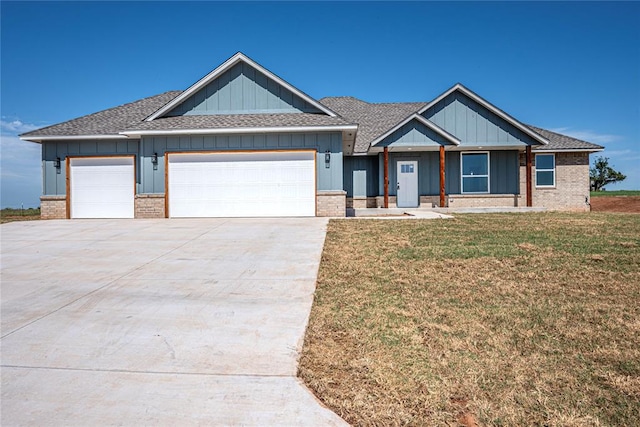 craftsman inspired home featuring a front yard and a garage