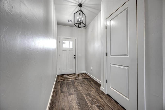 doorway to outside featuring dark hardwood / wood-style floors and an inviting chandelier